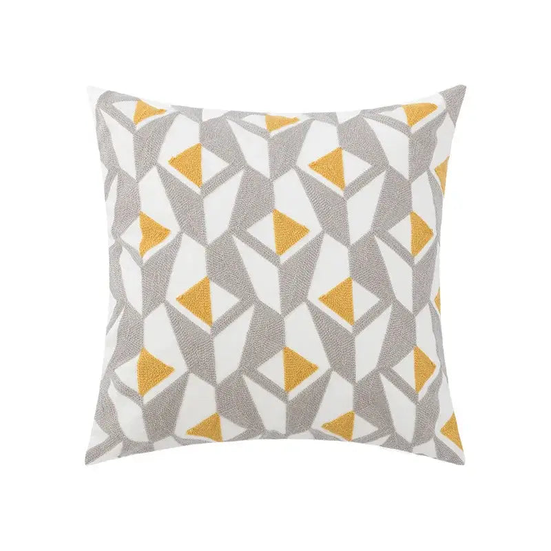 Square throw pillow with geometric embroidery of gray and mustard-yellow triangles on white decorbites daisy floral background