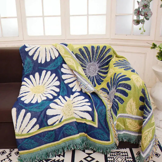 A cozy navy and white daisy flower knitted blanket with lime green floral pattern and fringed edges for living room decorbites decor