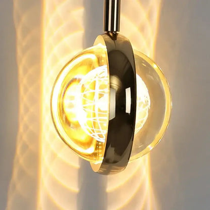 Modern spherical pendant light with polished brass finish and clear glass globe featuring an exposed bulb for dining room decorbites dandelion crystal ball