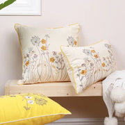 Cream-colored pillow cover with yellow and gray dandelion floral embroidery and matching yellow piping trim decorbites dandelion floral