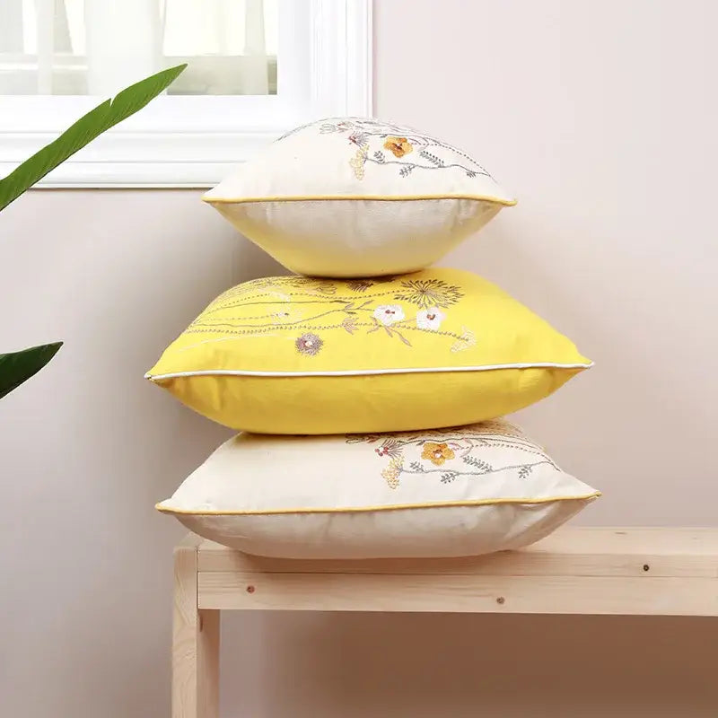 Stacked cream and yellow pillow covers with delicate dandelion floral embroidery for decorbites dandelion floral decor