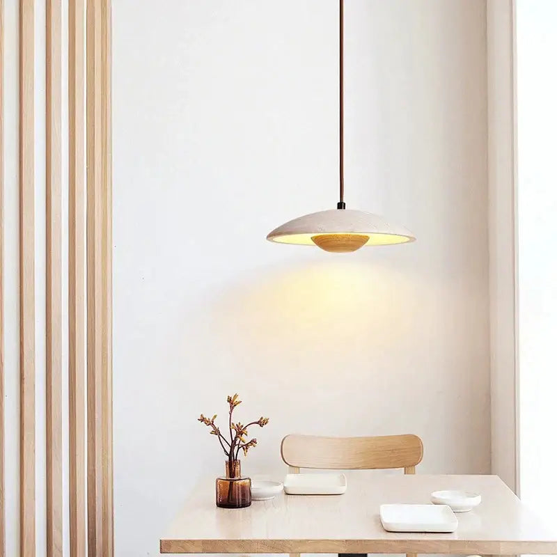 Minimalist cream stone pendant lamp with matte beige ceramic shade and warm glowing interior for bedroom decorbites cream stone