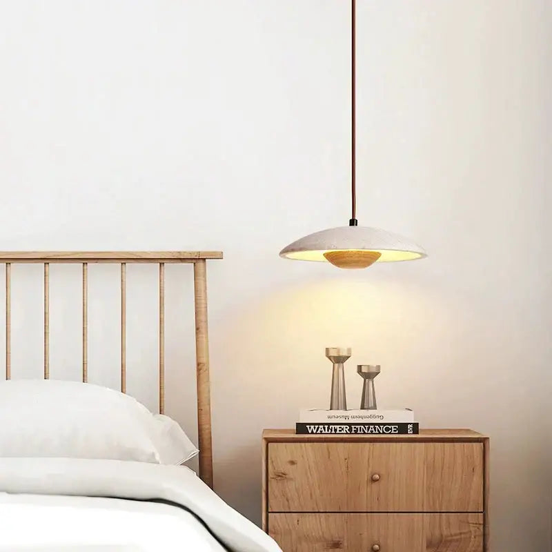 Minimalist cream stone pendant lamp with a matte white disc shade and warm interior lighting for bedroom decorbites cream stone