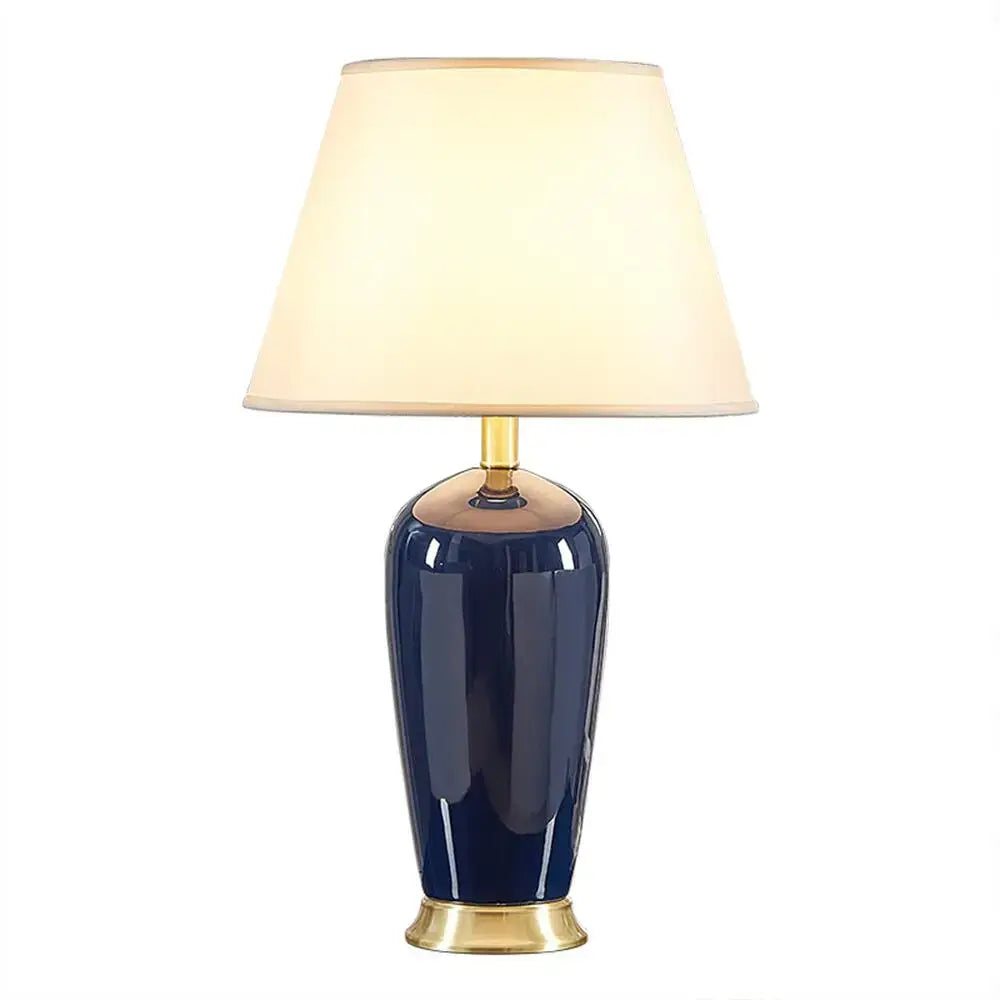 Dark blue ceramic table lamp with cream fabric shade gold metal accents and remote control by decorbites for bedroom use