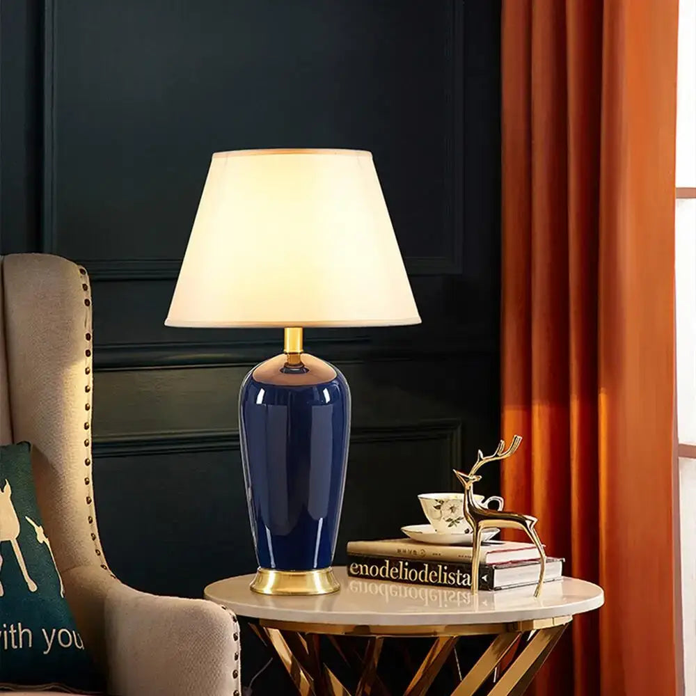 Dark blue ceramic table lamp with remote control featuring gold-toned base and cream fabric shade for bedroom decorbites