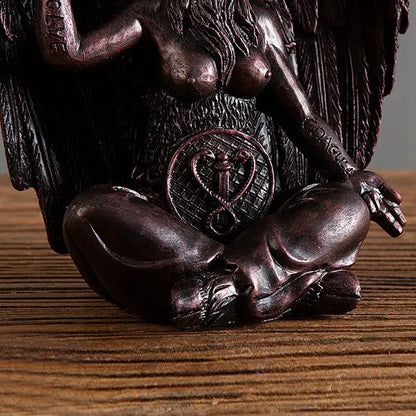 Dark bronze baphomet horned devil statue with long hair seated in meditation pose over a skull for gothic decor