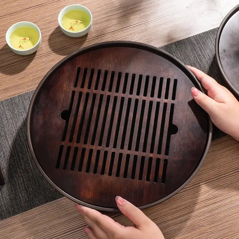 Dark brown bamboo tea tray drainage board with vertical slits and side cutouts for kung fu tea in dining room