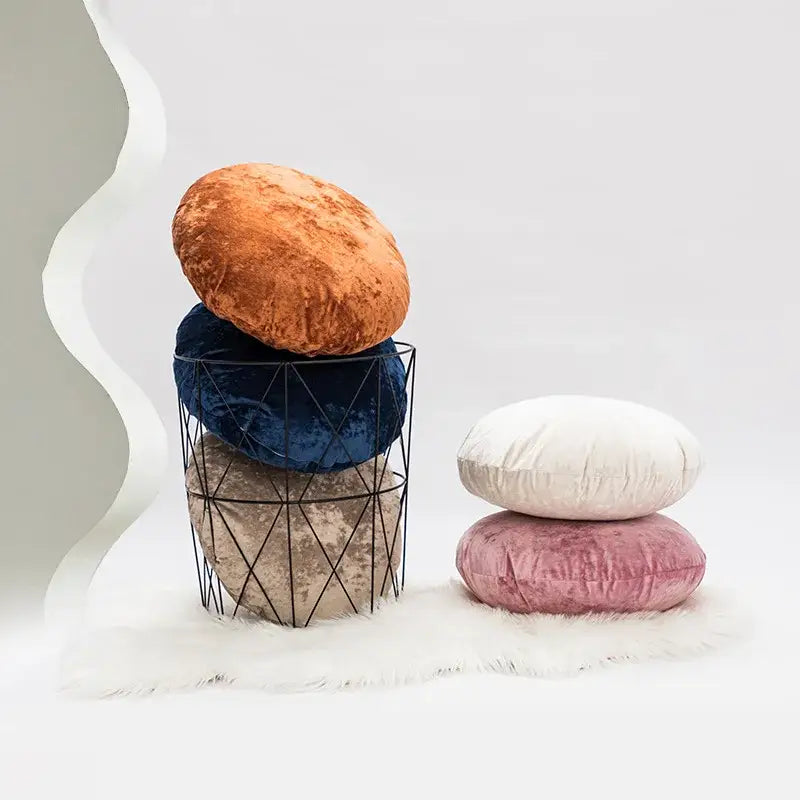 Stacked dark grain velvet pillow covers in warm orange navy blue and muted taupe in a black wire basket decorbites dark grain