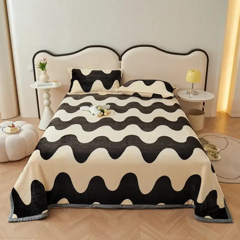 Dark gray cartoon print flannel sofa cover with black and cream fleece blanket featuring a wavy abstract pattern