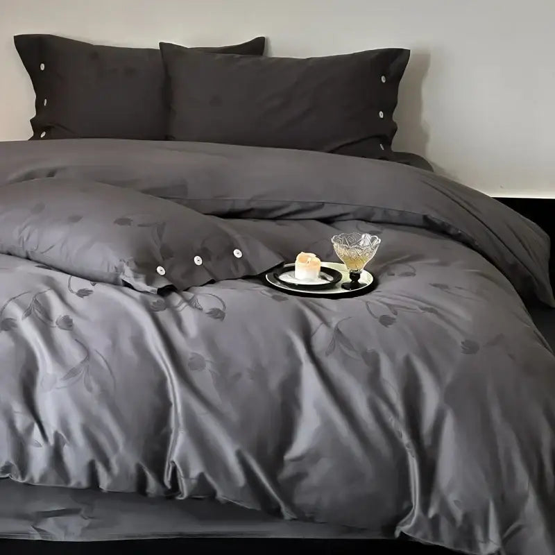 Dark gray egyptian cotton bedding set with subtle floral embroidery and button detailing on pillowcases in a bedroom