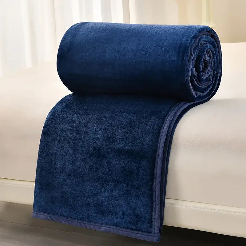 A plush navy blue fleece blanket rolled neatly on white surface from decorbites cozy flannel living room sofa cover