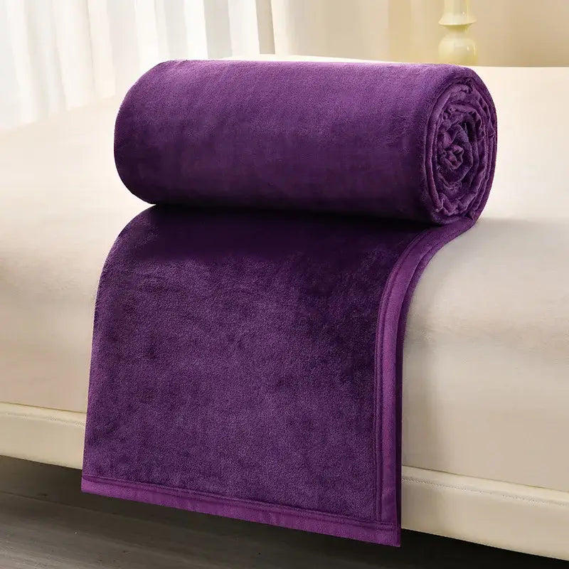 A plush deep purple fleece blanket rolled neatly on a light surface for decorbites cozy flannel living room use