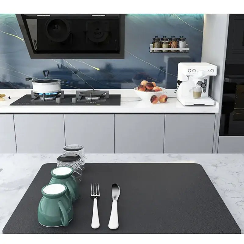 Dark gray silicone decorbites coffee mat with absorbent texture holding teal mugs and silverware on black placemat