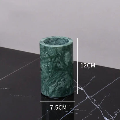 A cylindrical dark green marble candle holder with polished surface and natural veining from decorbites bathroom set