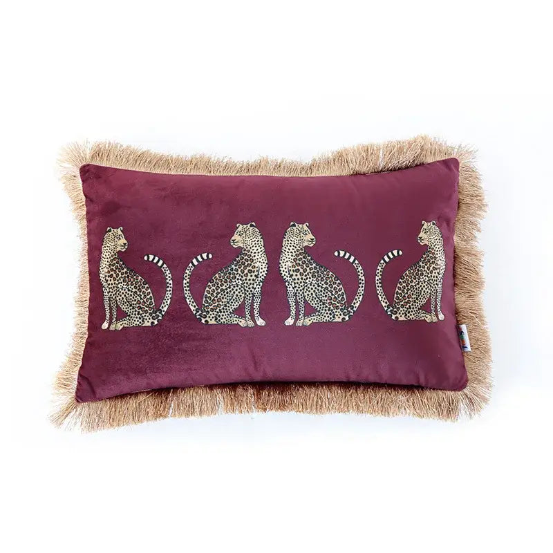 A plush maroon velvet cushion cover with embroidered leopard cheetah print and tan fringe from decorbites for living room decor