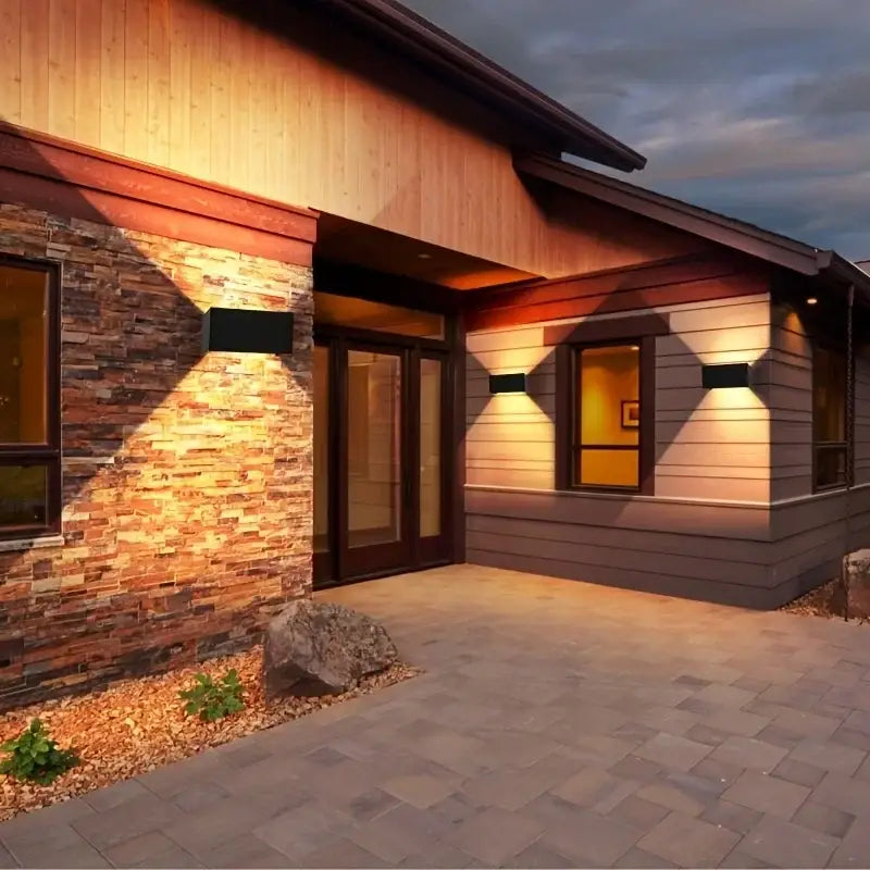 Modern black minimalist 24w led wall light outdoor sconce illuminating the entrance of a home with rectangular design