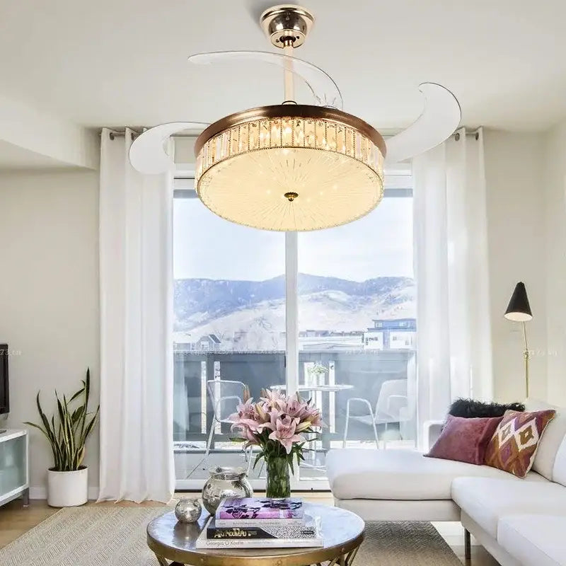 Modern gold crystal ceiling fan with retractable blades, brass frame, crystal accents, white blades, and remote control