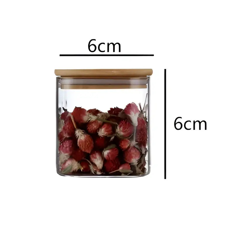 A clear 6cm glass jar from DecorBites 5oz glass set with bamboo lid filled with dried red flowers