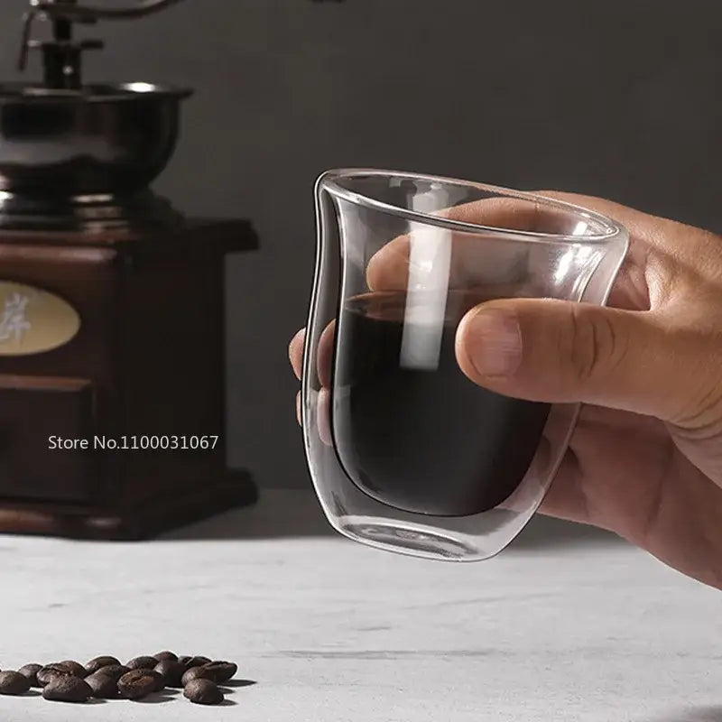 Clear double wall glass coffee mug held in hand filled with dark liquid from decorbites double wall coffee mugs set