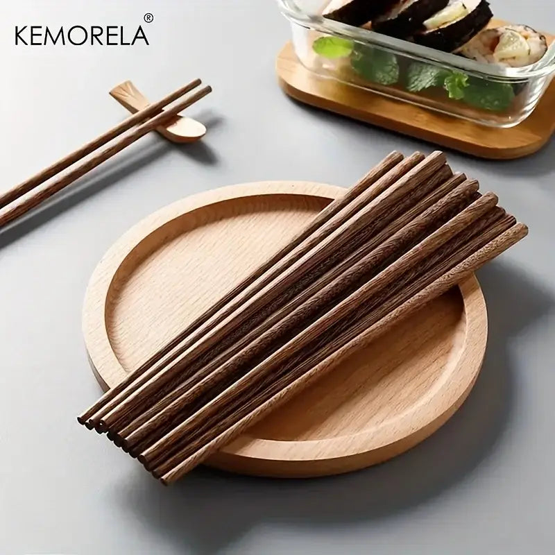 Set of dark brown natural wooden chopsticks with wood grain texture on a light circular plate for dining experience