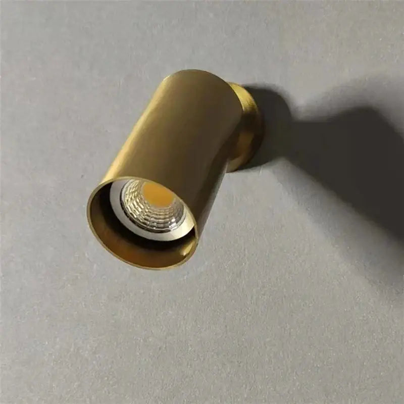 A sleek cylindrical brass-finished decorbites 5w copper led ceiling recessed spotlight with replaceable e27 bulb visible inside