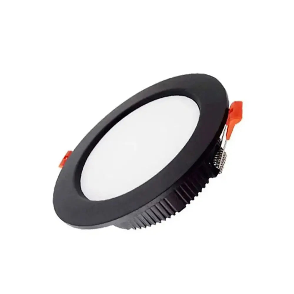Black circular DecorBites™ 5W led downlight with textured rim and orange clips for bright recessed ceiling in home living room