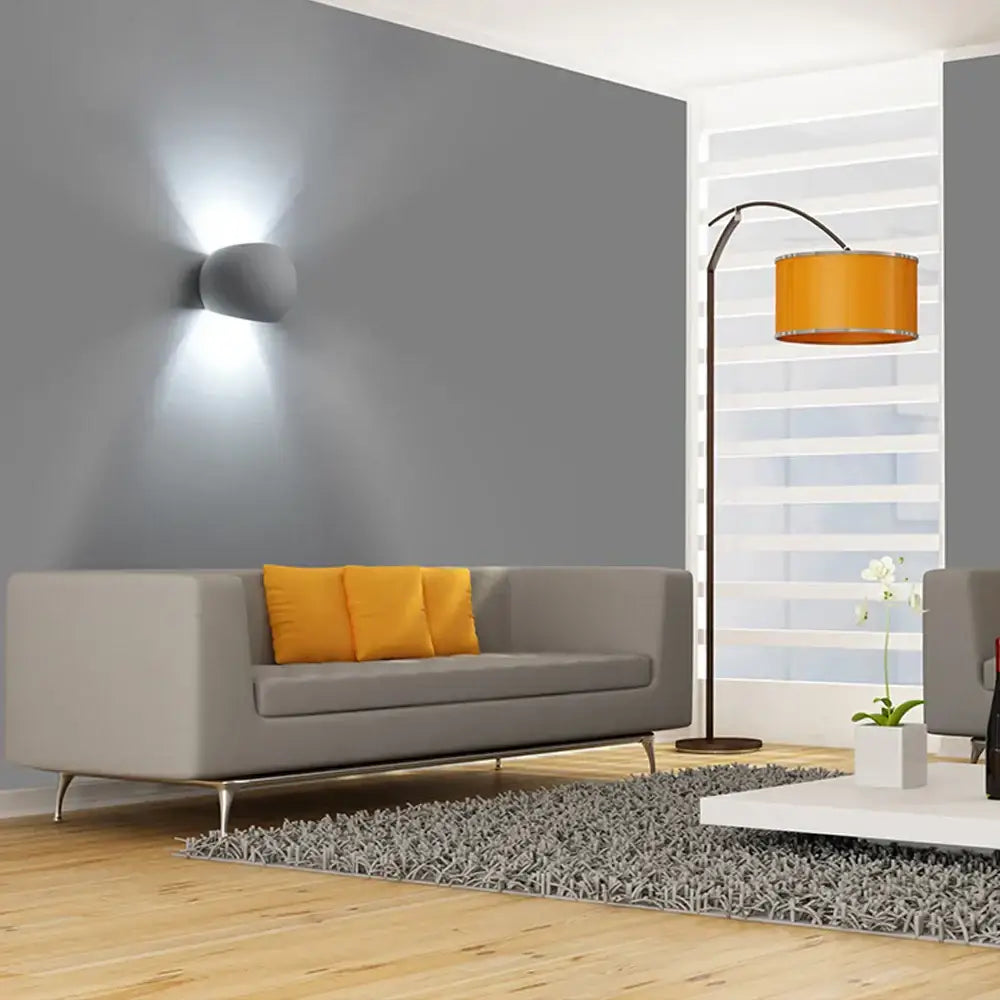 Gray modern sofa with orange pillows illuminated by decorbites™ 5w led gypsum wall lamp for living room lighting