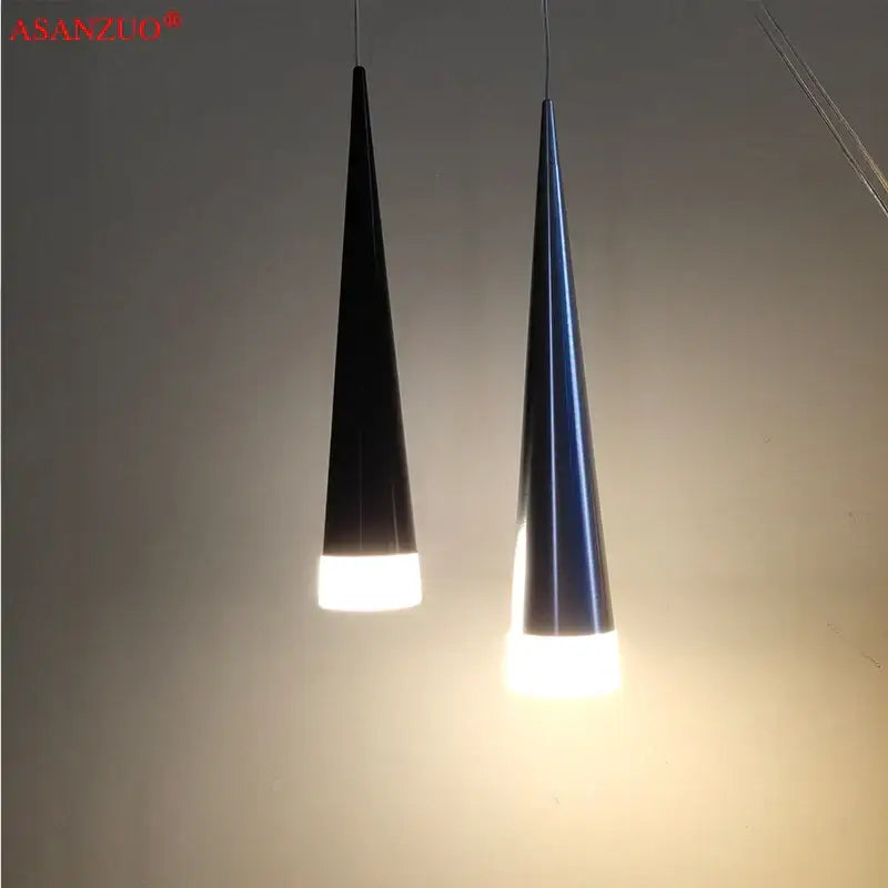 Two sleek silver black aluminum led pendant lights with cone shapes emitting warm white light for kitchen island