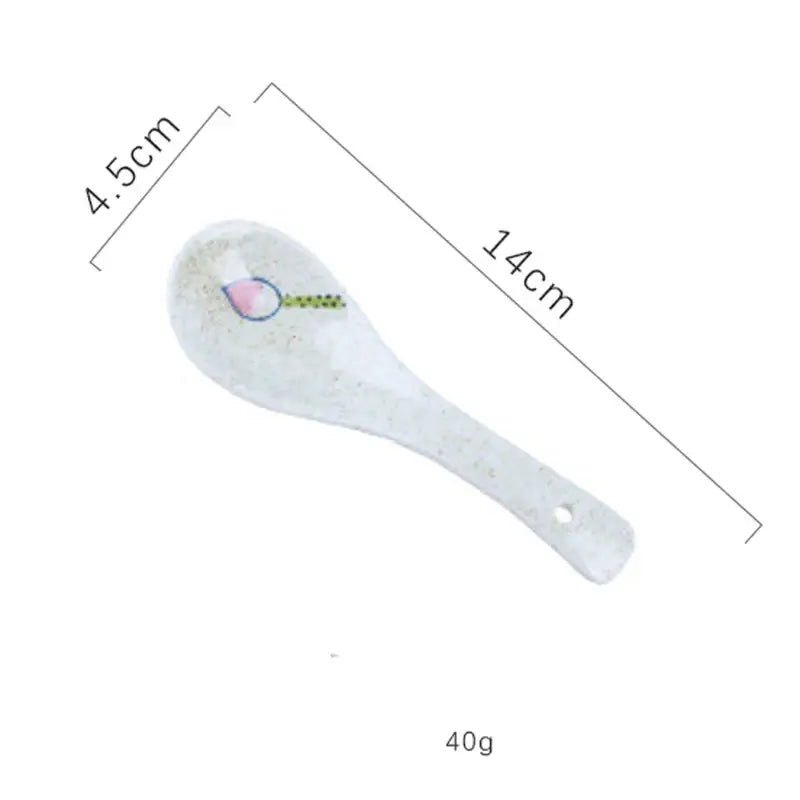 A white ceramic ramen bowl spoon with delicate pink and green design and a hanging hole for kitchen and hotel use