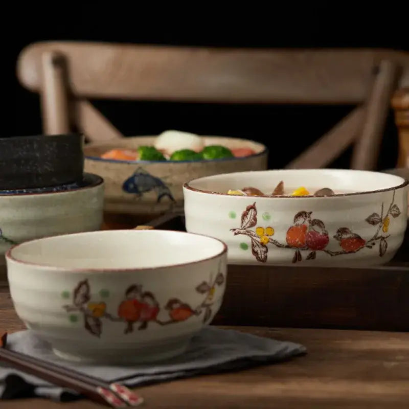 White ceramic ramen bowl with hand-painted fruit and bird motifs and rustic brown rim for kitchen and hotel use