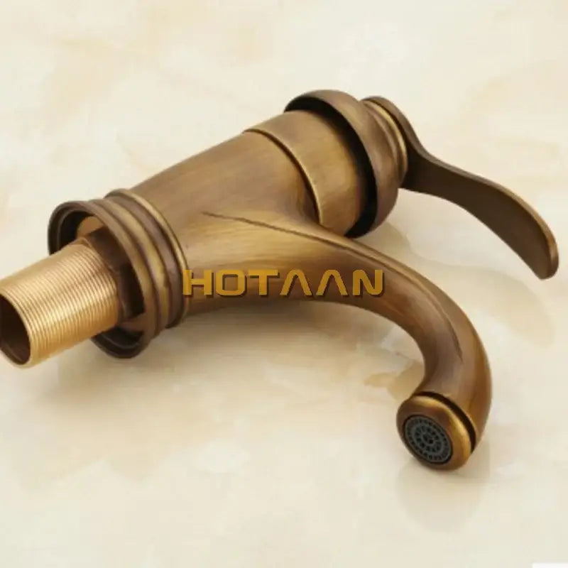 Decorbites™ 6 inch antique brass basin faucet with single handle curved spout and decorative ridged detailing in antique brass finish