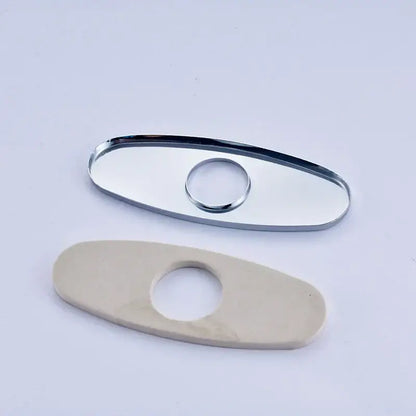 Chrome-finished oval deck plate cover with central hole paired with off-white ceramic plate cover for bathroom sink faucet
