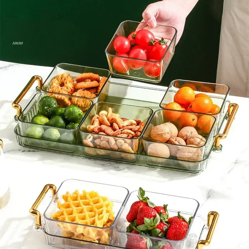 Clear glass DecorBites 6-grid divided fruit plate with gold-tone handles and compartments holding assorted snacks