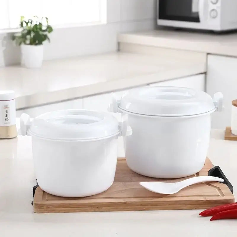 White ceramic 6-in-1 cooking pot with matching lids and side handles on wooden board for steaming and cooking