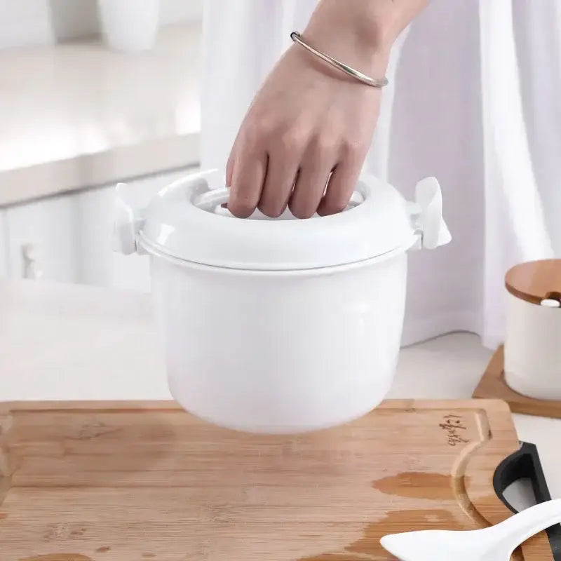 White ceramic 6-in-1 cooking pot with lid and side handles for meal preparation including steaming and cooking rice
