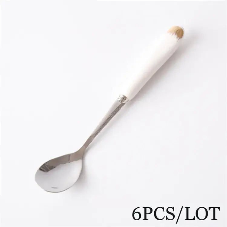 A sleek stainless steel coffee spoon with a tapering white european bone china handle from decorbites spoon set