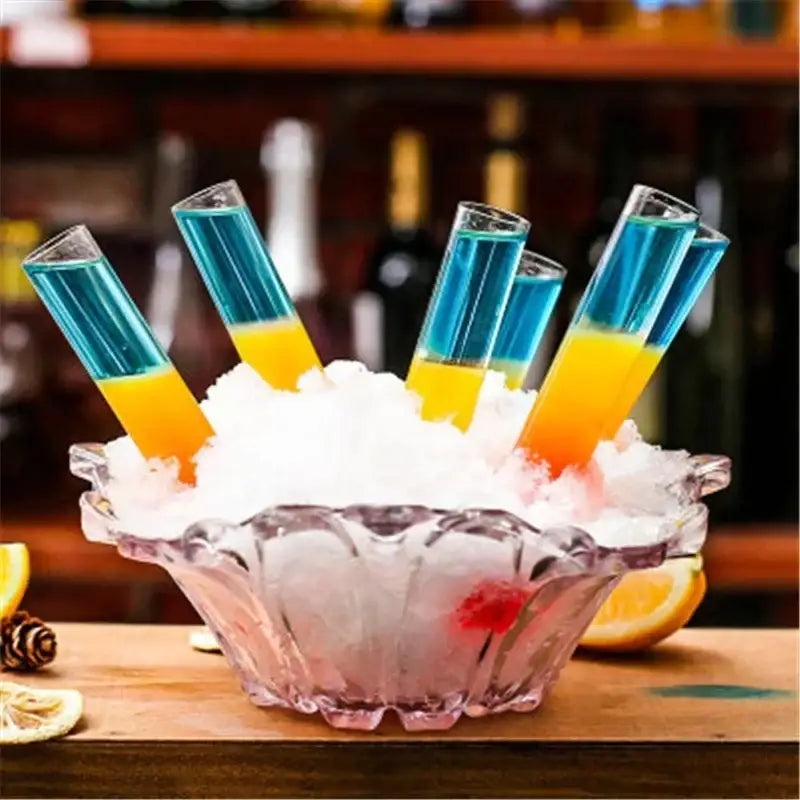 A clear glass bowl with crushed ice holding colorful DecorBites™ test tube cocktail glasses and shot glass holder