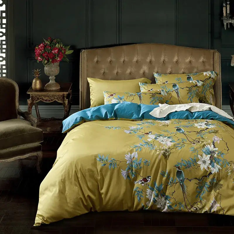 Yellow duvet cover with blue and white bird and floral embroidery paired with teal comforter in 600tc egyptian cotton bedding set
