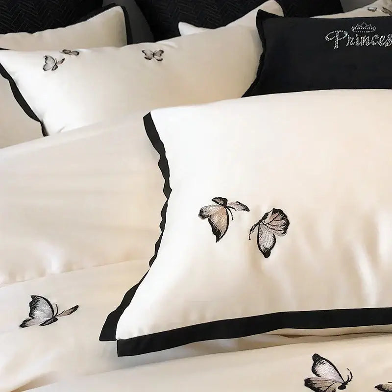 Cream-colored satin pillowcase with black embroidered butterflies and border from decorbites 600tc egyptian cotton bedding set