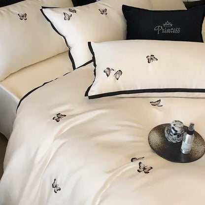Cream-colored satin bedding set with black butterfly embroidery and border made from 600tc egyptian cotton