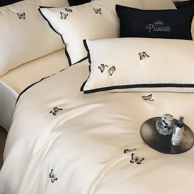 Cream-colored satin bedding set with black butterfly embroidery and border made from 600tc egyptian cotton