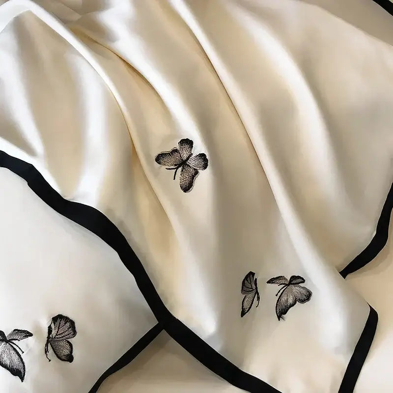 Cream-colored silk scarf with delicate black butterfly embroidery and border complementing 600TC Egyptian cotton bedding set
