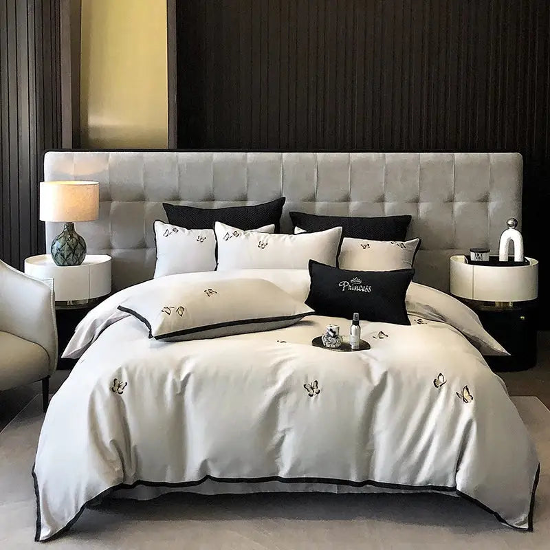 Elegant ivory satin bedding set in 600tc Egyptian cotton with black butterfly embroidery and matching tufted headboard