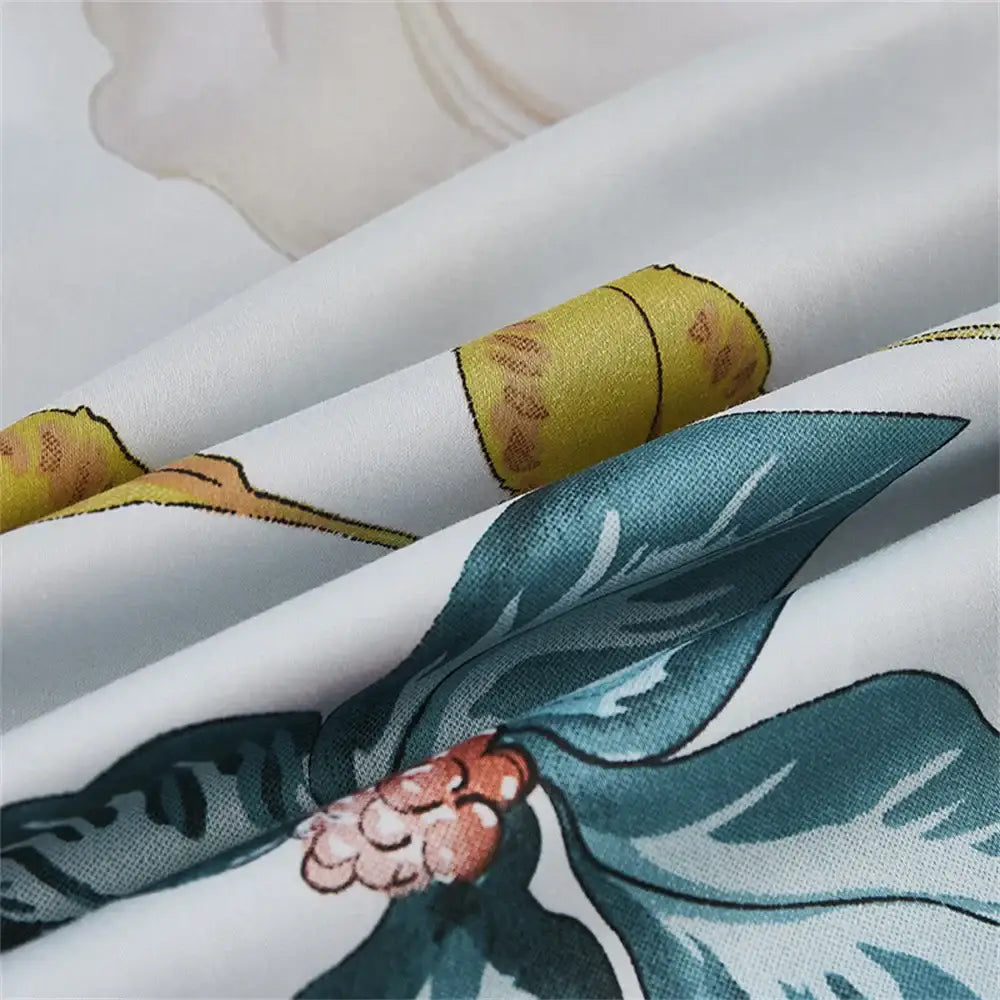 White fabric bedding set with printed teal leaves orange blossoms and yellow bands made of 600tc egyptian cotton