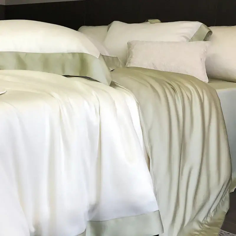 Elegant white satin lyocell eucalyptus fiber bedding set with sage green piping and matching pillowcases by decorbites