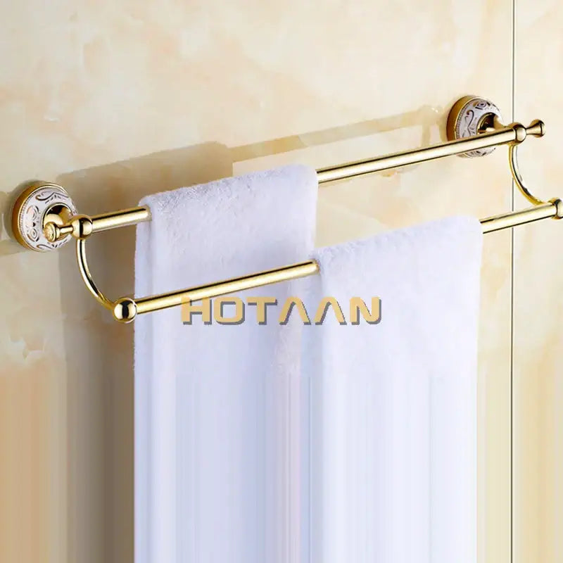 Gold-colored decorbites™ 60cm double towel bar with ceramic gold finish and ornate patterned wall mounts