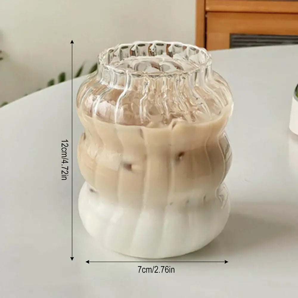 Clear ribbed glass tumbler with white ceramic base containing gradient iced coffee in decorbites 650ml latte ribbed glass