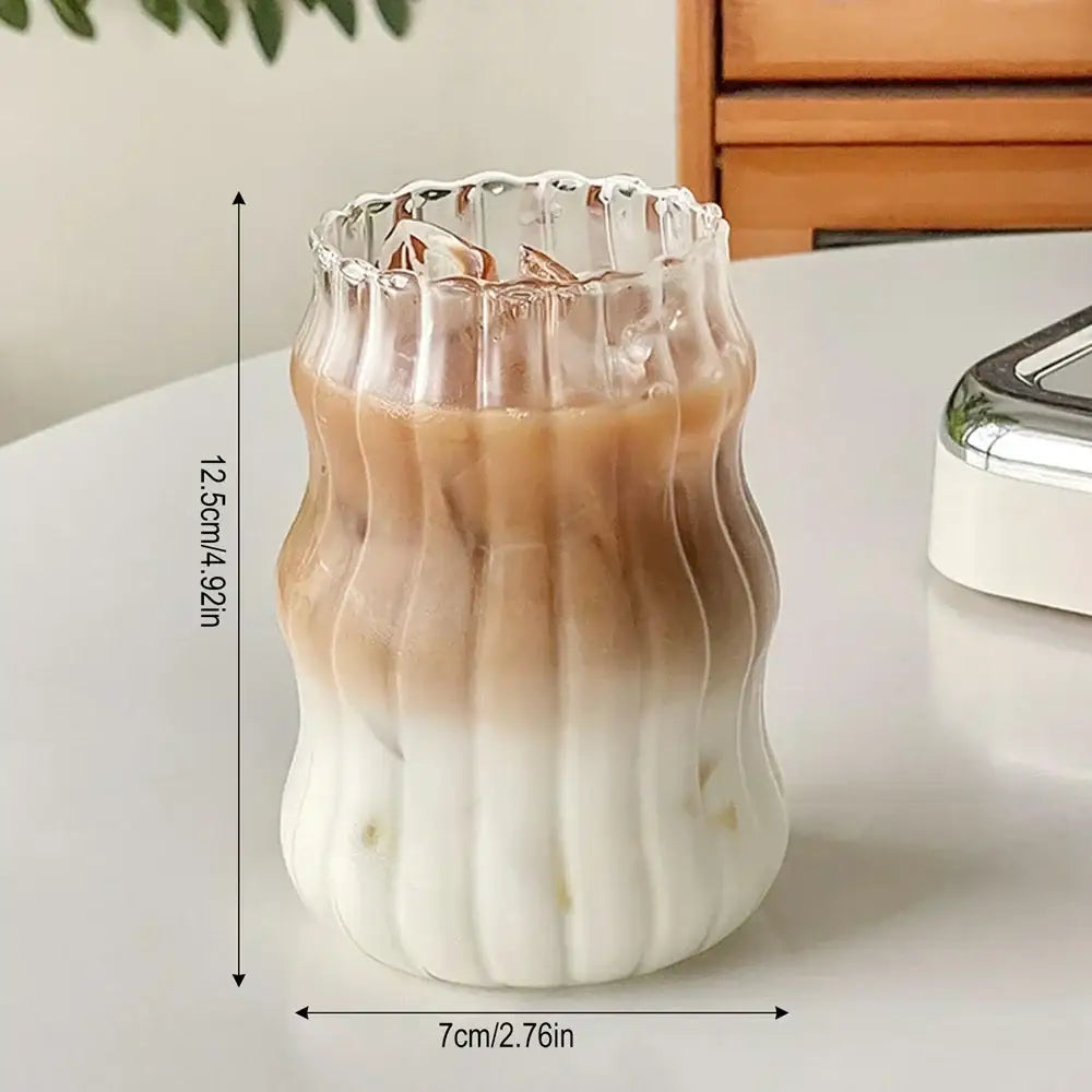 A clear ribbed cocktail glass with a fluted rim filled with gradient iced coffee in the decorbites 650ml latte ribbed set