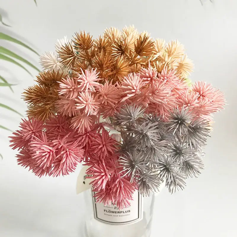 A 6pcs dried flower mix of artificial spiky flowers in pink silver and gold in a clear glass vase for decorbites crafts
