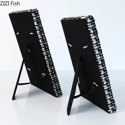 Black rectangular 6x7 inch fabric framed photo frames with sparkling silver beaded border on black metal easel stands